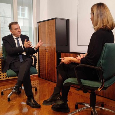 Generalni direktor Robert Ljoljo sedi na stolu in razlaga osebi, ki ga intervjuja